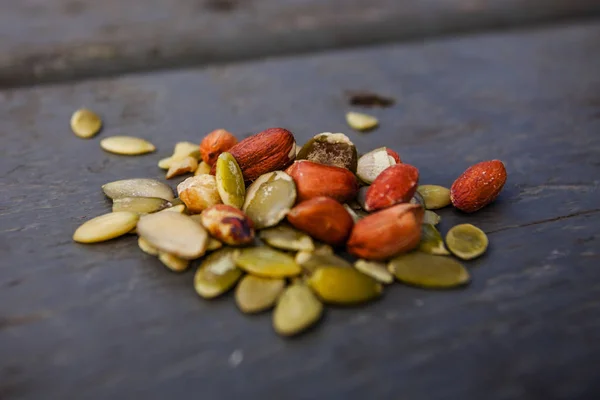 Amendoins descascados crus e sementes de abóbora na mesa de madeira — Fotografia de Stock