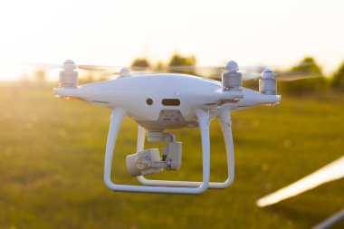 Günbatımında gökyüzünde bir dron. Dışarıdaki kuadrokopteri kapatın..