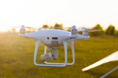 Günbatımında gökyüzünde bir dron. Dışarıdaki kuadrokopteri kapatın..