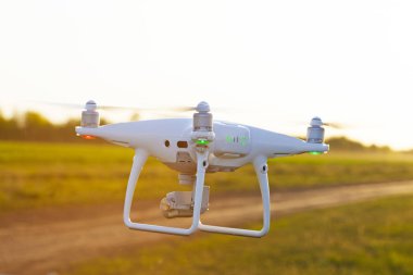 Günbatımında gökyüzünde bir dron. Dışarıdaki kuadrokopteri kapatın..