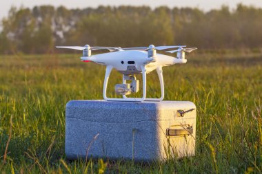 Günbatımında gökyüzünde bir dron. Dışarıdaki kuadrokopteri kapatın..