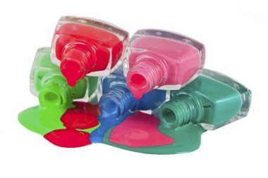 Beyaz arka planda dökülmüş ojeli şişeler.