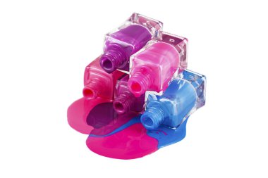 Beyaz arka planda dökülmüş ojeli şişeler.