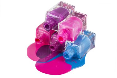 Beyaz arka planda dökülmüş ojeli şişeler.