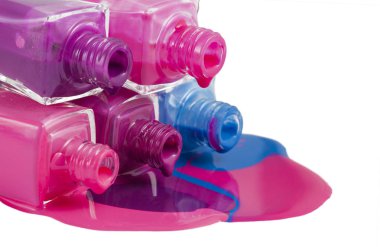 Beyaz arka planda dökülmüş ojeli şişeler.