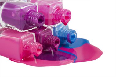 Beyaz arka planda dökülmüş ojeli şişeler.