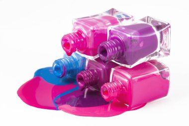 Beyaz arka planda dökülmüş ojeli şişeler.