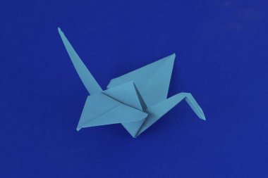 Mavi arka plan üzerinde mavi origami vinç