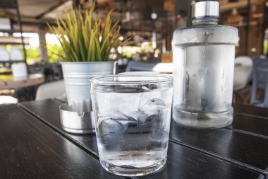 Atina sahil kafe masada su şişesi woth cam, Greese