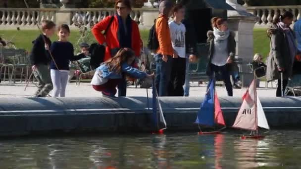 2014年10月8日 子供たちはパリで2番目に大きい公園である人気のあるリュクサンブール公園でモデルボートを帆走する方法を学んでいます ルクセンブルク宮殿は背景にあります — ストック動画