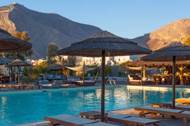 Yunanistan 'ın Perissa kentinde gün batımında kafede yüzme havuzu