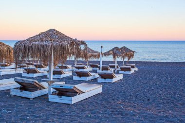 Perissa sahilindeki şemsiyeler, gün batımı zamanı, Yunanistan
