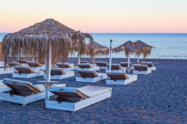 Perissa sahilindeki şemsiyeler, gün batımı zamanı, Yunanistan