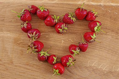 Ahşap arka planda parlak kırmızı yaz çileği