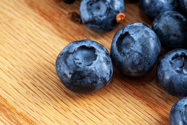 Ahşap arka planda taze mavi sulu yaban mersini