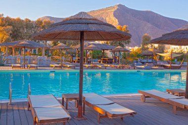 Yunanistan 'ın Perissa kentinde gün batımında kafede yüzme havuzu