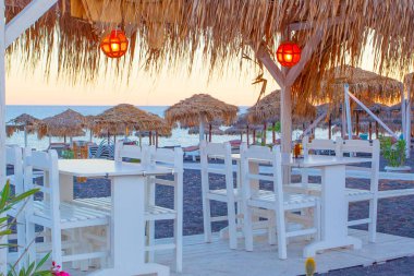 Yunanistan 'ın Santorini adasındaki Perissa plajı yakınlarındaki masalar