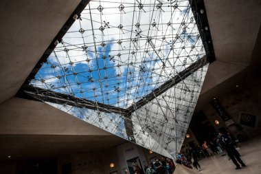 PARIS - 3 Ekim 2016: 3 Ekim 2016 'da Paris, Fransa' da alışveriş merkezi 'Carrousel du Louvre' da insanlarla çevrilmiş piramit. Louvre Müzesi dünyanın en büyük sanat koleksiyonlarından birine ev sahipliği yapıyor..