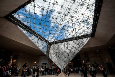 PARIS - 3 Ekim 2016: 3 Ekim 2016 'da Paris, Fransa' da alışveriş merkezi 'Carrousel du Louvre' da insanlarla çevrilmiş piramit. Louvre Müzesi dünyanın en büyük sanat koleksiyonlarından birine ev sahipliği yapıyor..
