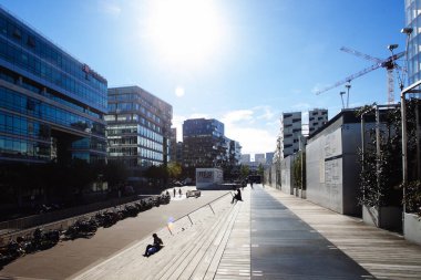 Paris, Fransa - 5 Ekim 2016: Paris 'teki Fransız Ulusal Kütüphanesi kuleleri ve güneşli bir günde plazaya çıkan merdivenler, ahşap merdivenlerde kitap okuyan insanlar