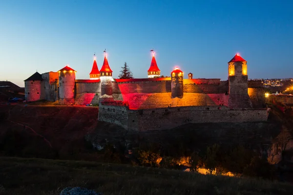 Kamianets-Podilskyi gece ortaçağ kalesi. Gece cityscape ışıklı eski kale, Ukrayna