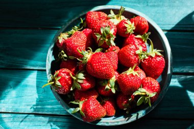 Yeşil plaka üzerinde yeşil ahşap masa güzel fişek ve gölge ile taze çilek