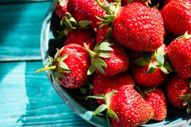 Yeşil plaka üzerinde yeşil ahşap masa güzel fişek ve gölge ile taze çilek