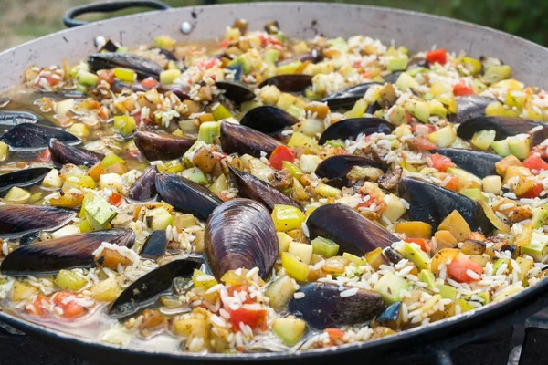 Process of cooking paella with mussels and crayfish