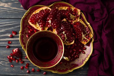 nar ve bordo bir bez yakınındaki bir masada kırmızı suyu fincanla