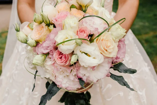 Beautiful wedding rustic bouquet with white roses. In bride hand