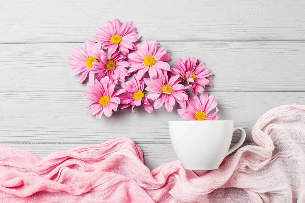 pink gerbera flowers fly out of a cup of tea
