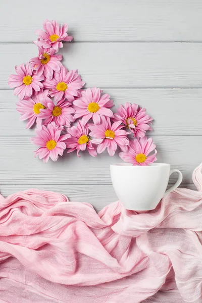 pink gerbera flowers fly out of a cup of tea