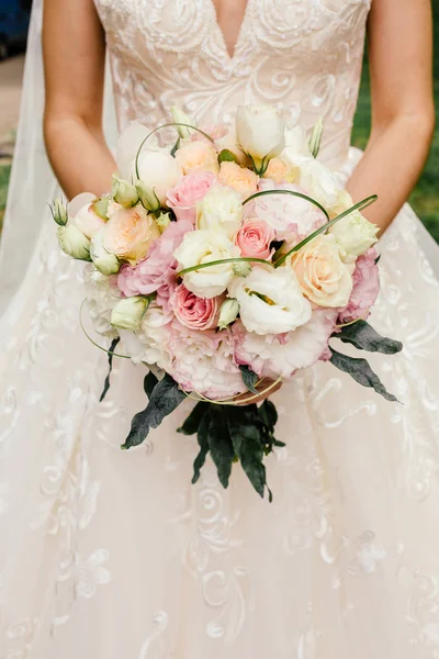 Beautiful wedding rustic bouquet with white roses. In bride hand