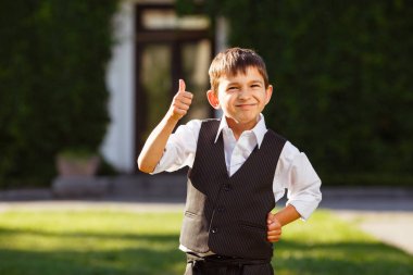 Neşeli çocuk günbatımı yeşil çim üzerinde şık elbiseli