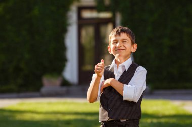 Neşeli çocuk günbatımı yeşil çim üzerinde şık elbiseli