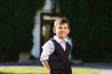 Neşeli çocuk günbatımı yeşil çim üzerinde şık elbiseli