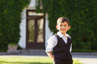 Neşeli çocuk günbatımı yeşil çim üzerinde şık elbiseli
