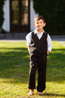 Neşeli çocuk günbatımı yeşil çim üzerinde şık elbiseli