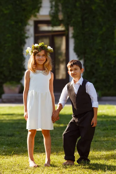 Girl White Dress Holds Boy Hand Fashionable Suit Park Sunset — Stock Photo, Image
