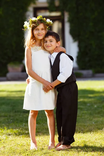 Beyaz elbiseli bir kız bir erkek moda takım elbiseli sarılmak. Park, günbatımı