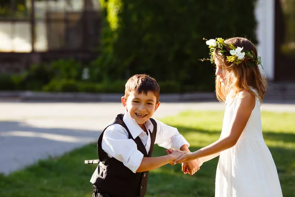 Beyaz elbiseli bir kız Park, şık elbiseli bir çocukla dans günbatımı