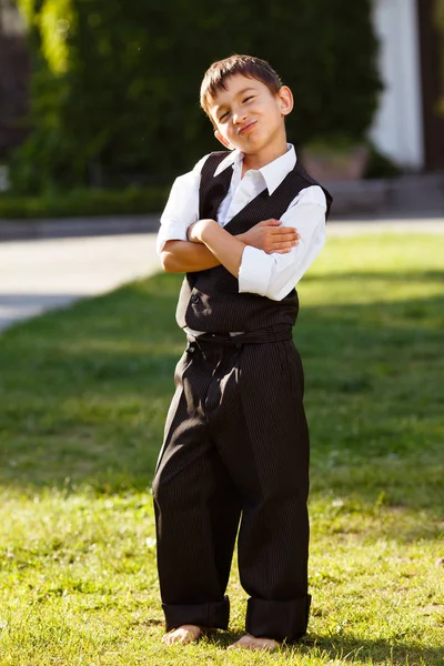 Neşeli çocuk günbatımı yeşil çim üzerinde şık elbiseli