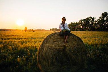Batan güneşin kırsal yaşam tarzı, Ulusal gelenekleri kavramı arka planda alanındaki işlemeli giysili bir kızı