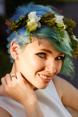 Mavi saç ve gerçek çiçek çelenk ile güzel bir gelin portresi. Düğün günü. . Ormanda güzel gelin portre.