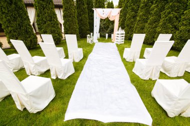 Düğün kemer açık havada bir bez ile dekore edilmiştir. Güzel düğün tuzak kurdu. Bahçede yeşil çim üzerinde düğün töreni. Festival dekor parçası.