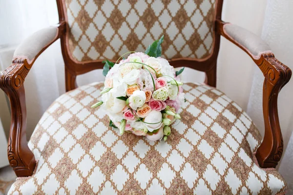 Wedding bouquet on an antique armchair with carved armrests