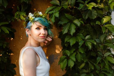 Mavi saç ve gerçek çiçek çelenk ile güzel bir gelin portresi. Düğün günü. . Ormanda güzel gelin portre.