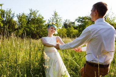 Genç düğün çifti bir yaz çayır dışında romantik anları zevk. Mavi saçlı kız.