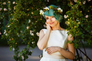 Mavi saç ve gerçek çiçek çelenk ile güzel bir gelin portresi. Düğün günü. . Ormanda güzel gelin portre.