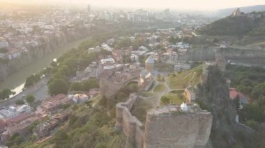 Narikala kalesindeki Aziz Niklas Kilisesi 'ne hava manzarası ve gün doğumunda Tiflis' in güzel panoramik manzarası. Gürcistan, Doğu Avrupa